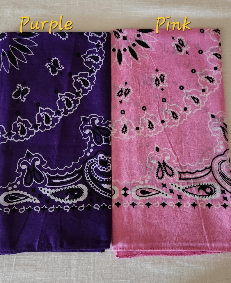 May include: Two square bandanas featuring a traditional paisley pattern in black and white. One bandana is deep purple, and the other is light pink. The text Purple is printed above the purple bandana, and the text Pink is above the pink one.