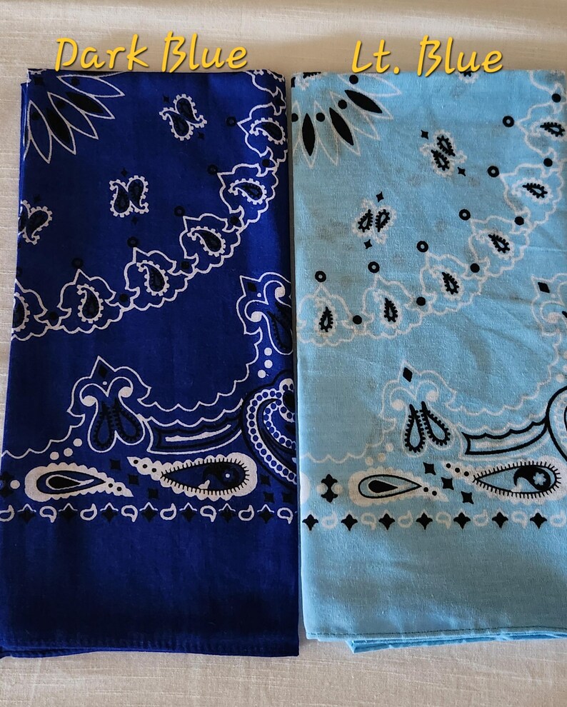May include: Two square bandanas featuring a traditional paisley pattern in white and black. One bandana is dark blue, and the other is light blue. The text "Dark Blue" is printed above the dark blue bandana, and "Lt. Blue" is above the light blue one.