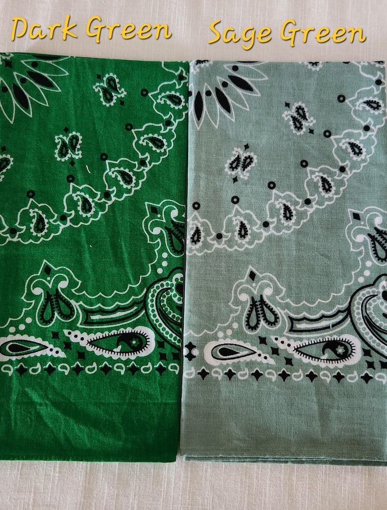 May include: Two folded bandanas featuring a traditional paisley pattern in black and white. The left bandana is dark green, and the right bandana is sage green. The text Dark Green and Sage Green is printed above each respective fabric piece.