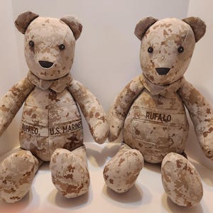 May include: Two camouflage teddy bears, one with the text "U.S. MARINES" and the other with the text "RUFFALO" on their chests.