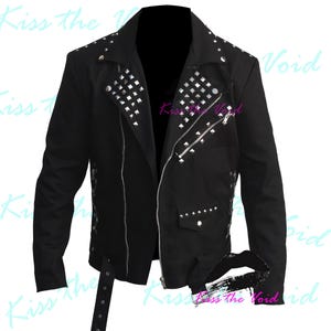 May include: Black jacket with silver studs and zippers. The jacket has a classic biker style with an asymmetrical zipper closure, a notched collar, and a belt at the waist. The jacket is decorated with silver square studs.