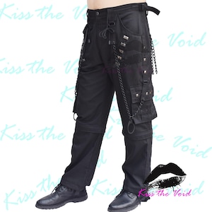 May include: Black cargo pants with multiple pockets, chains, and studs. The pants have a drawstring waist and a relaxed fit.