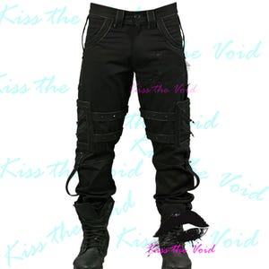 May include: Black cargo pants with multiple pockets, straps, and rivets. The pants have a distressed look and are paired with black boots. The text "Kiss the Void" is visible in the background.
