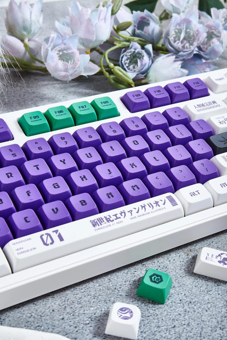 May include: A white mechanical keyboard with purple and green keycaps. The keyboard has a custom keycap set with the text "新世紀エヴァンゲリオン EVANGELION 01 NERV" and a graphic of the Evangelion Unit 01. The keyboard is surrounded by white flowers.
