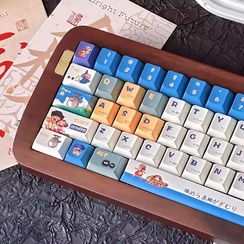 May include: A wooden keyboard with blue and white keys featuring Japanese characters and illustrations of characters from the animated film My Neighbor Totoro. The keyboard has a blue and white space bar with the text "温めらゑ絶がざむり" in Japanese.