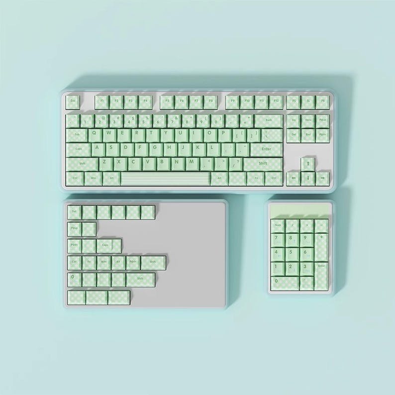 May include: A light blue keyboard with a light green keycap set. The keyboard has a number pad and a separate set of keys for function keys. The keyboard is on a light blue background.