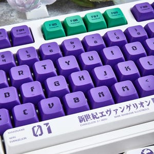 May include: A white mechanical keyboard with purple and green keycaps. The keyboard has a space bar with the text "EVANGELION 01 NERV" and "MARI MAKINAMI ILLUSTRIOUS" printed on it. The keyboard also has a keycap with the text "01" printed on it.