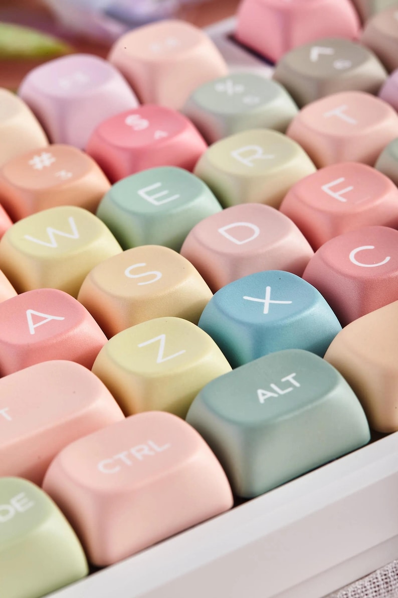 May include: A pastel-colored keyboard with keys labeled with letters of the alphabet, numbers, and symbols. The keys are in a variety of pastel colors, including pink, blue, green, and yellow.
