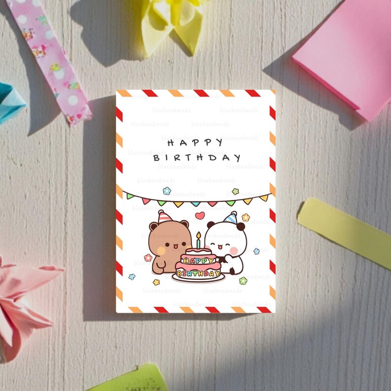 May include: A white card with red and orange stripes around the edges. The card has a banner that says "Happy Birthday" and a picture of two cartoon bears celebrating with a cake. The cake has the words "Happy Birthday" on it.