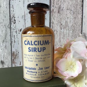 Zeldzame Duitse apothekersfles uit de jaren 1920. Antieke amberkleurige glazen fles, medische eigenaardigheid, calciumsiroop. Farmaceutisch decor, cadeau voor dokter.