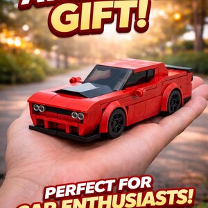 Op de afbeelding: Een rode speelgoedauto met zwarte accenten, waaronder wielen en een motorkap, wordt getoond. De tekst "AWESOME GIFT!" en "PERFECT FOR CAR ENTHUSIASTS!" zijn zichtbaar. De auto wordt in een hand gehouden.