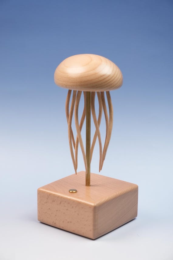 A hand-carved wooden automata where a jellyfish actually undulates via a mechanical crank — part toy, part sculpture, total conversation piece.