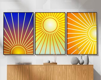 May include: Three framed abstract sunburst prints with yellow, orange, and blue gradients. The prints are hanging on a white wall above a wooden cabinet.