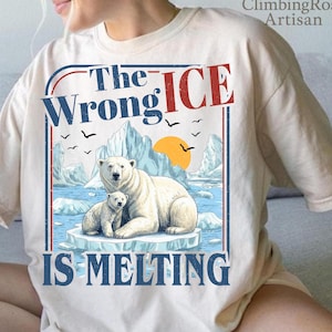 May include: Cream-colored t-shirt featuring a graphic of a polar bear and cub on an ice floe, with the text "The Wrong Ice Is Melting." The design includes a blue and red border, a yellow sun, and flying birds.