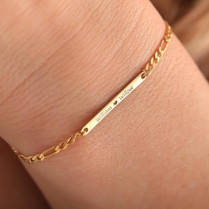 May include: Gold chain bracelet with a personalized bar charm engraved with "William ♥ Willow".