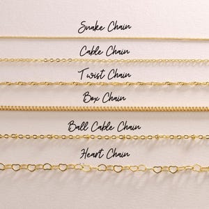 May include: A selection of gold-colored chain necklaces, including snake, cable, twist, box, ball cable, and heart chains. Each chain style is labeled with elegant cursive text. The chains are displayed against a neutral background.
