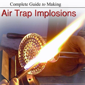 Puede incluir: Demostración de soplado de vidrio con el texto "Complete Guide to Making Air Trap Implosions". Una llama amarilla brillante se dirige a una esfera de vidrio con una superficie texturizada, sostenida con herramientas de metal.