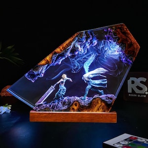 Puede incluir: Lámpara de resina que representa una escena de batalla con dos figuras, una con una espada grande. La lámpara tiene una base de madera y un interior azul y morado brillante, con un borde marrón y naranja. La lámpara está encendida.