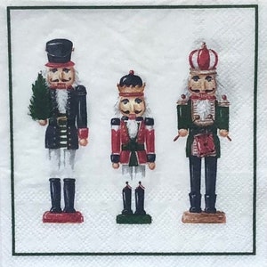May include: Three wooden nutcracker figurines with painted details. The nutcracker on the left is holding a small green tree. The middle nutcracker is wearing a red and gold uniform. The nutcracker on the right is wearing a green and gold uniform.
