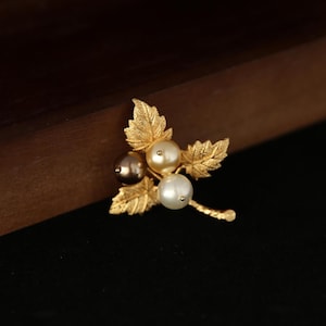 Op de afbeelding: Een set van drie keramische mokken met een gespikkelde, matte afwerking. De mokken zijn in crème, lichtgrijs en donkergrijs. Elke mok heeft een eenvoudig, minimalistisch ontwerp en een afgeronde handgreep.