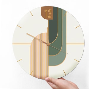 May include: A white circular clock with gold and green geometric shapes and gold hands. The clock face has the number 12 in gold.
