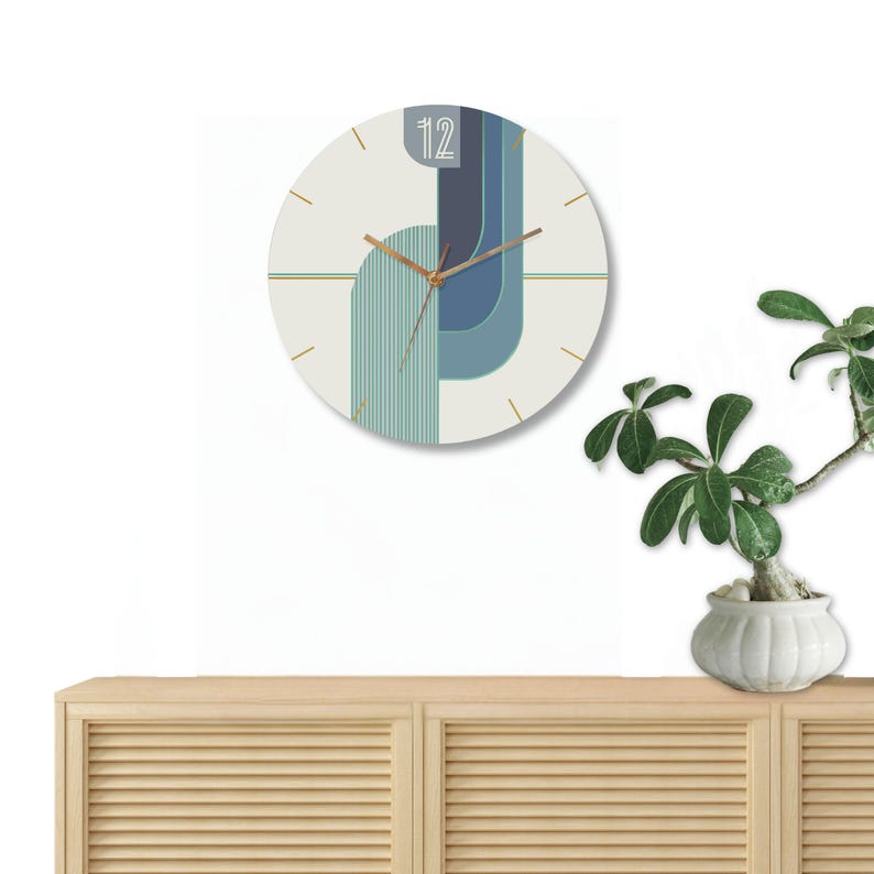 May include: A white and blue geometric design clock with gold hands and a gold trim. The clock is hanging on a white wall above a wooden cabinet with slatted doors.
