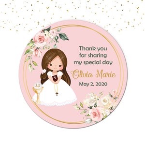 May include: Pink and white round sticker with a floral design. A girl in a white dress holds a book and a cross. The text reads "Thank you for sharing my special day Olivia Marie May 2, 2020".