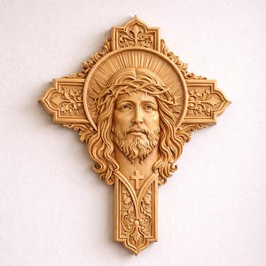 May include: A detailed wooden cross carving featuring the face of Jesus with a crown of thorns, a halo, and a beard. The cross is intricately carved with floral and geometric patterns, and is mounted on a white wall.