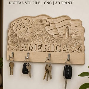 Peut inclure: Un porte-clés mural en bois clair avec un relief sculpté représentant un aigle, un phare et un drapeau avec le texte AMERICA. L'objet comporte quatre crochets métalliques portant chacun un trousseau de clés, avec l'inscription DIGITAL STL FILE | CNC | 3D PRINT.