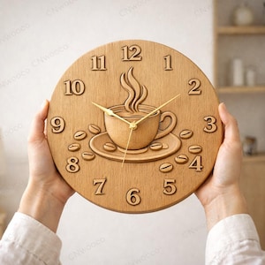 Könnte beinhalten: Eine runde Wanduhr aus Holz mit einem Kaffeetassen-Design, Dampf, Kaffeebohnen und goldenen Zeigern. Die Uhr hat eine hellbraune Oberfläche und wird von zwei Händen gehalten. Die Zahlen 1 bis 12 sind angezeigt.