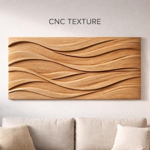 Puede incluir: Una pieza rectangular de arte mural de madera con una textura fluida en forma de olas. La obra de arte es de color marrón claro y está montada en una pared blanca sobre un sofá beige. El texto "CNC TEXTURE" está encima de la obra.