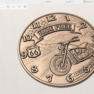 May include: A bronze-colored coin featuring a motorcycle and the text "RIDE FREE" above it. The coin also displays the text "ROUTE 66" and numbers around the edge, resembling a clock face. The design is detailed and three-dimensional.