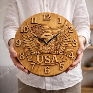 May include: A round wooden clock featuring a carved American bald eagle with outstretched wings, an American flag, and the word "USA". The clock has black hands and large, raised numerals. The clock is approximately 12 inches in diameter.