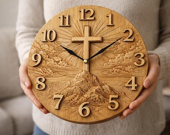 Puede incluir: Un reloj redondo de madera con una cruz tallada en el centro. La esfera del reloj presenta números en relieve y un diseño de paisaje montañoso. Las manecillas del reloj son negras.