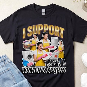 Może przedstawiać: Czarny t-shirt z napisem I SUPPORT WOMEN'S SPORTS złotymi i białymi literami. Grafika zawiera cztery zdjęcia osoby w żółtym fartuchu i różowych rękawiczkach, wykonującej prace domowe, takie jak pranie i zmywanie naczyń.