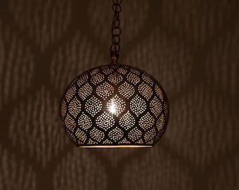 May include: A round, gold-toned pendant light fixture with a geometric pattern. The light fixture is hanging from a chain and has a light bulb inside.