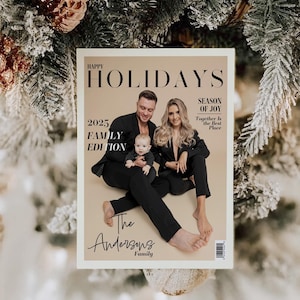 May include: A magazine cover with the headline "Happy Holidays" and the text "2025 Family Edition." The cover features a family of three in black outfits. The magazine is set against a backdrop of a Christmas tree with ornaments.