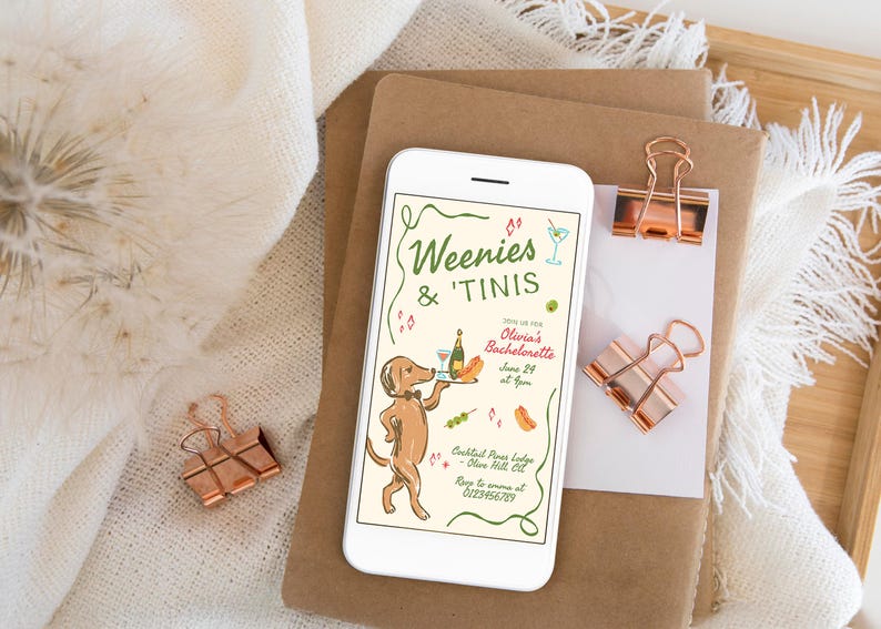 May include: A white smartphone displaying a bachelorette party invitation with the text Weenies & 'Tinis, featuring a brown dachshund wearing a bowtie and holding a tray with a bottle and glass, alongside illustrations of a hot dog and olives.