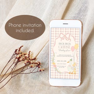 May include: A smartphone displays a digital invitation with the text "Duck Duck Goose, [Child's Name] is Two!" The invitation features a pink and beige color scheme with floral and balloon accents. A sprig of dried flowers and a brown oval with the text "Phone invitation included" are also in the image.
