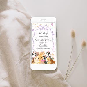 May include: A white smartphone displays a birthday party invitation with a dog theme. The invitation features a purple bow, paw prints, and a border with the text "Let's Party!" and "Emma's 5th Birthday". A variety of cartoon dogs are at the bottom.