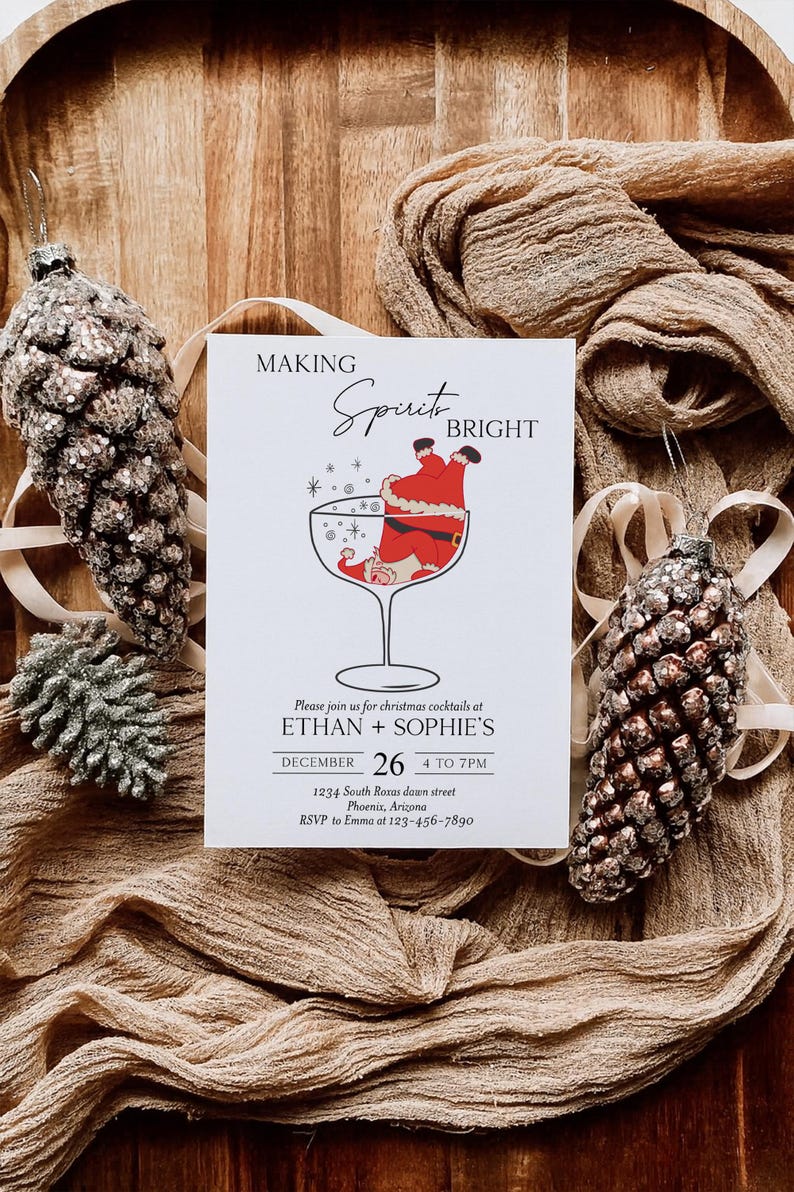 May include: A Christmas cocktail invitation with the text "MAKING Spirit BRIGHT". The invitation features a Santa Claus illustration in a cocktail glass. Two pinecone ornaments and fabric complete the festive scene.