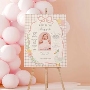 May include: A pink and white printable first birthday sign with a photo of a baby girl and a goose illustration. The sign includes the baby's name, age, height, weight, and the date of the birthday. The text reads "Alisa is one silly goose".