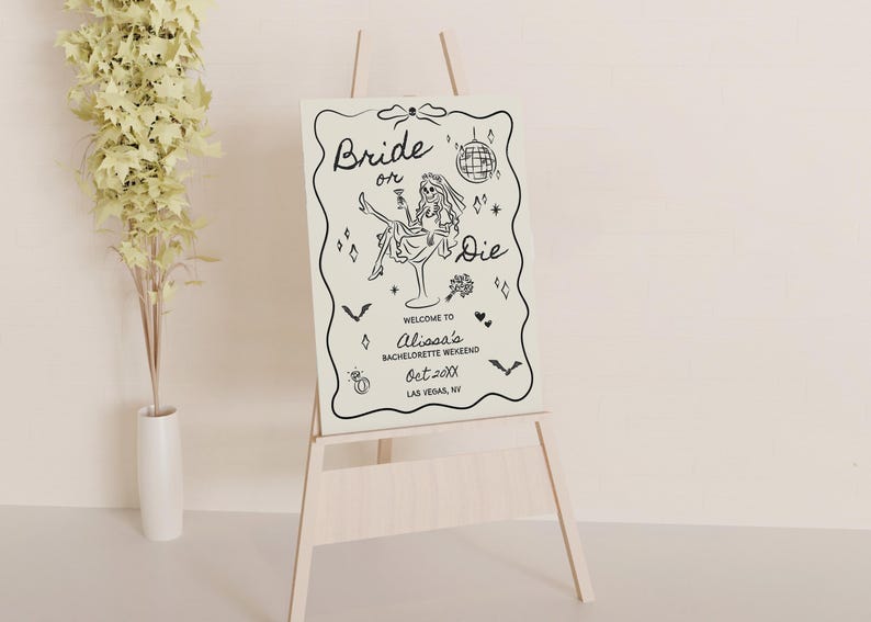 Pode incluir: Um cavalete de madeira clara exibe uma placa com as palavras "Bride or Die" em uma fonte extravagante. A placa apresenta uma ilustra&ccedil;&atilde;o em preto e branco de uma mulher em um copo de martini, com texto adicional e elementos decorativos. A placa &eacute; para um fim de semana de despedida de solteira.
