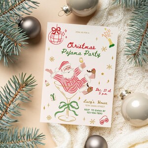 Op de afbeelding: Een feestelijke uitnodiging voor een kerstpyjamaparty met een illustratie van de kerstman in een martiniglas. De uitnodiging is versierd met sneeuwvlokken, kerstballen en dennentakken. De tekst luidt "Christmas Pajama Party".