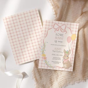 May include: A set of two baby shower invitations. The invitation features a bunny illustration, balloons, and the text "Some Bunny is One." The background is a pink and white gingham pattern.