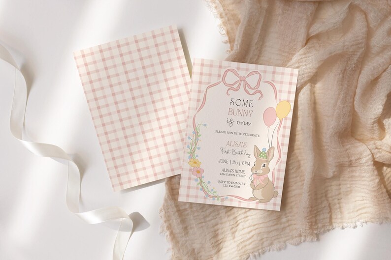 May include: A set of two baby shower invitations. The invitation features a bunny illustration, balloons, and the text "Some Bunny is One." The background is a pink and white gingham pattern.