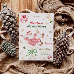 Op de afbeelding: Een uitnodiging voor een kerstpyjamaparty met een feestelijk ontwerp. De kaart toont de kerstman in een martini glas, met de tekst "Christmas Pajama Party". Decoratieve ornamenten en stof maken het thema compleet.