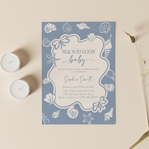 May include: A baby shower invitation with a blue background and seashell illustrations. The invitation reads "Sea You Soon Baby" and includes details for the event, such as the date, time, and location. Two white candles are on the left.