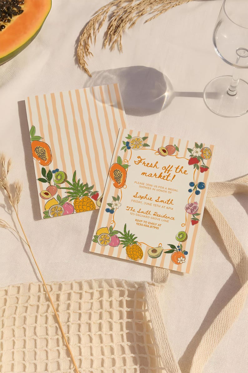 May include: Two rectangular paper cards with a light orange and white vertical stripe pattern. The cards feature colorful illustrations of various fruits including papaya, pineapple, and berries. The text reads: Fresh off the market! Please join us for a bridal shower in honor of Sophie Smith, Friday, June 15th at 6pm, The Smith Residence, 123 Orchard Grove Lane, RSVP to Emily at 123.456.87945.