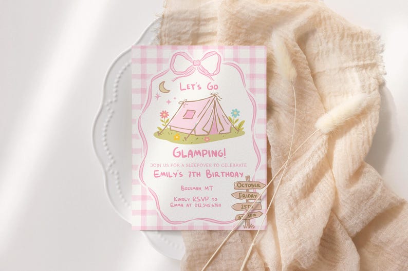 May include: A pink and white invitation card with a bow design at the top. The card features a tent illustration with the words "Let's Go Glamping!" and details for Emily's 7th birthday. The card is on a white plate with a beige fabric.